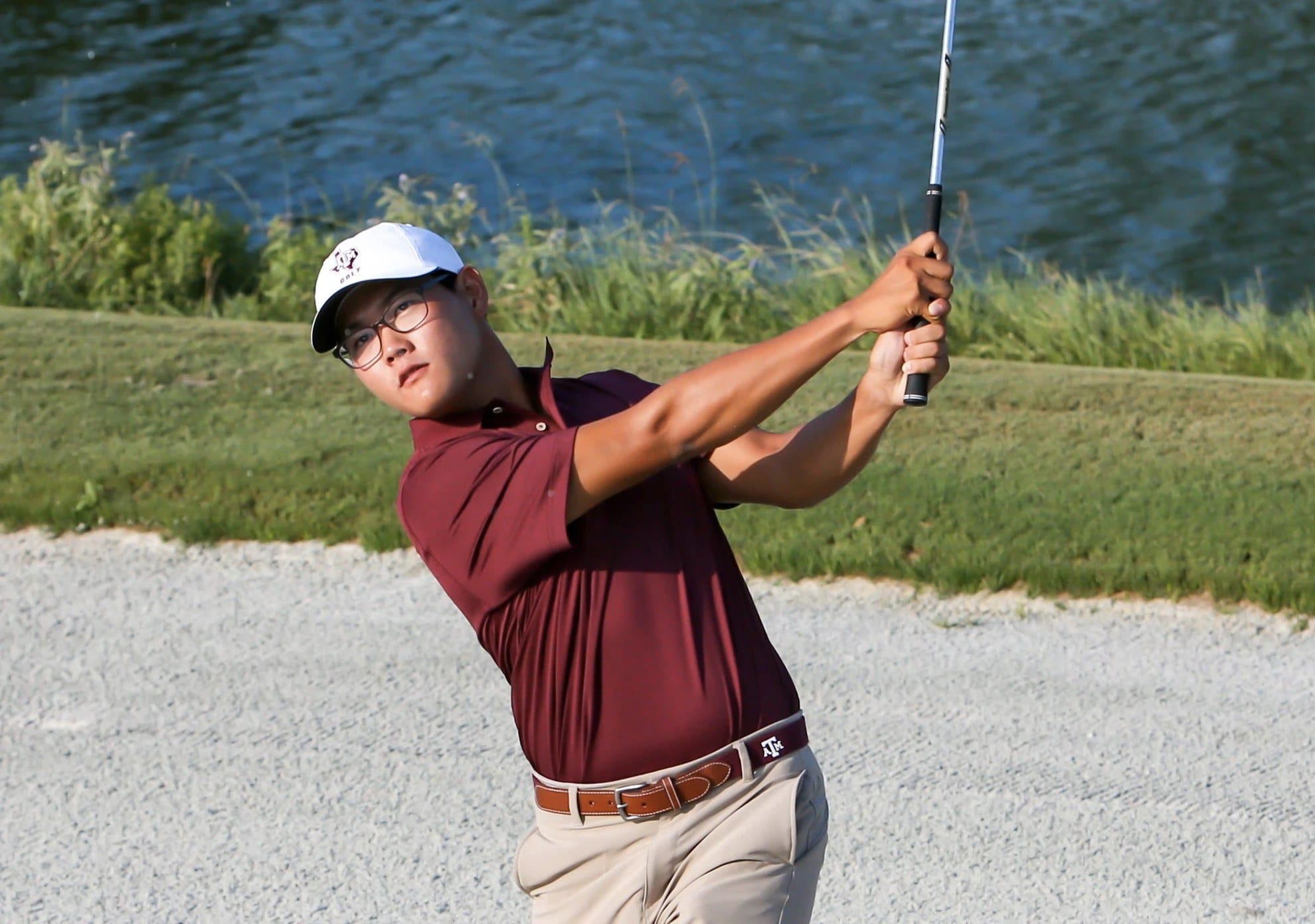 Jimmy Lee playing a shot beside a lake on the golf course