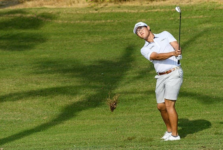 Jimmy Lee hitting an approach shot from the fairway